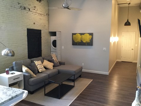 A living room with a grey couch and a black coffee table.