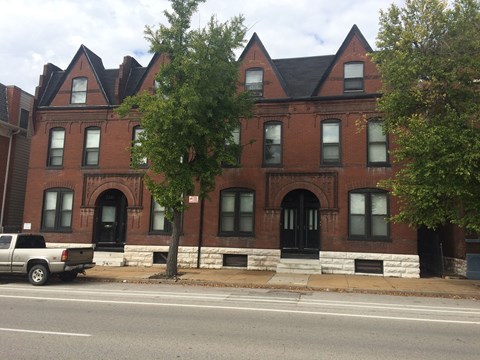 A red brick building with a black door and windows.