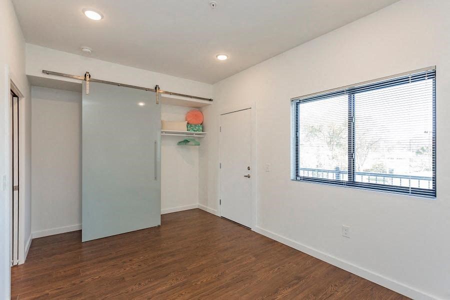 an empty room with a window and a closet