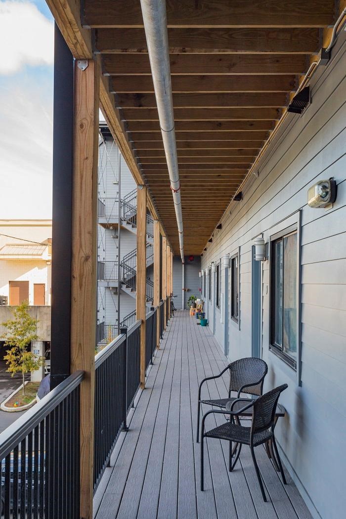 a long porch with chairs and a wooden roof