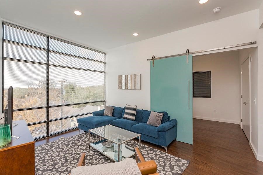 a living room with a blue couch and a glass table