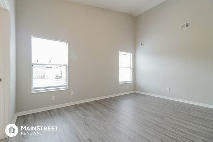 an empty room with wood floors and a window