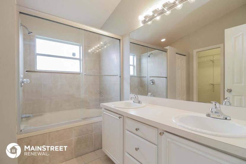 a white bathroom with two sinks and a shower