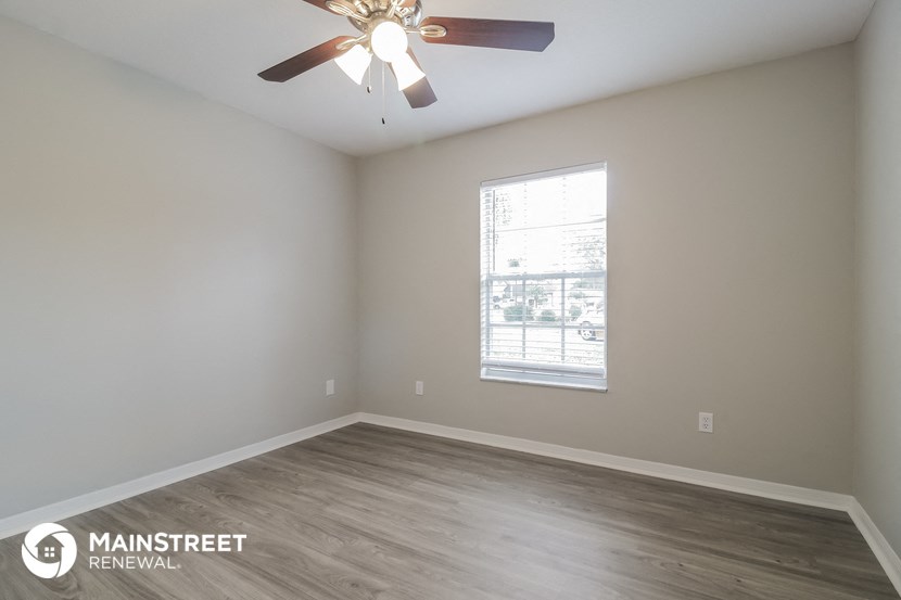a bedroom with a ceiling fan and a window