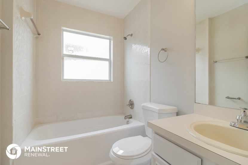 a white bathroom with a tub and a sink and a toilet