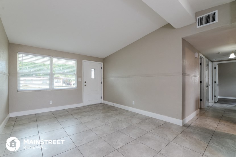 the living room and entryway of an empty house