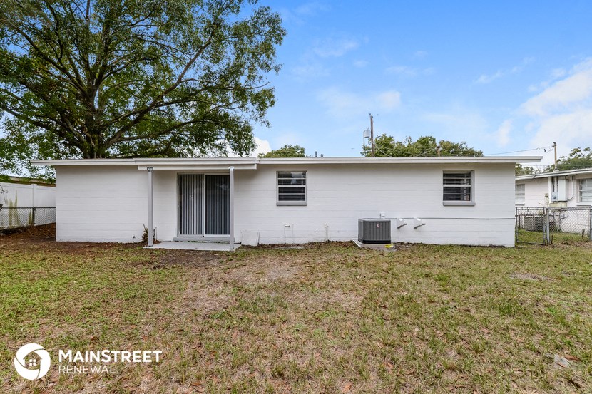 a small white house with a yard and a tree
