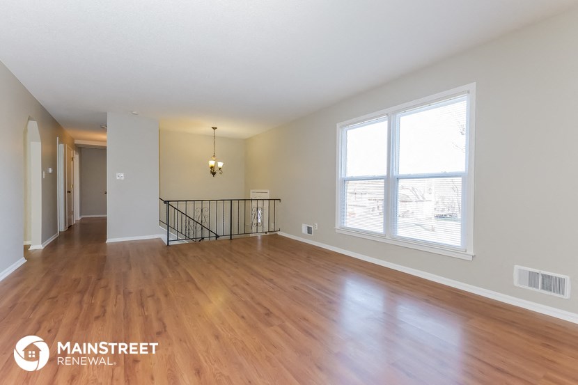 the living room and dining room with wood flooring and large windows