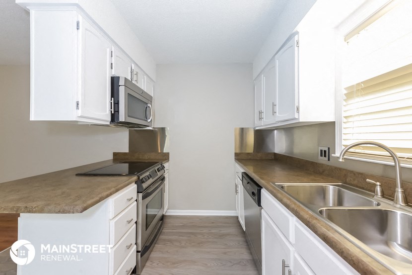 a kitchen with white cabinets and stainless steel appliances and a counter top
