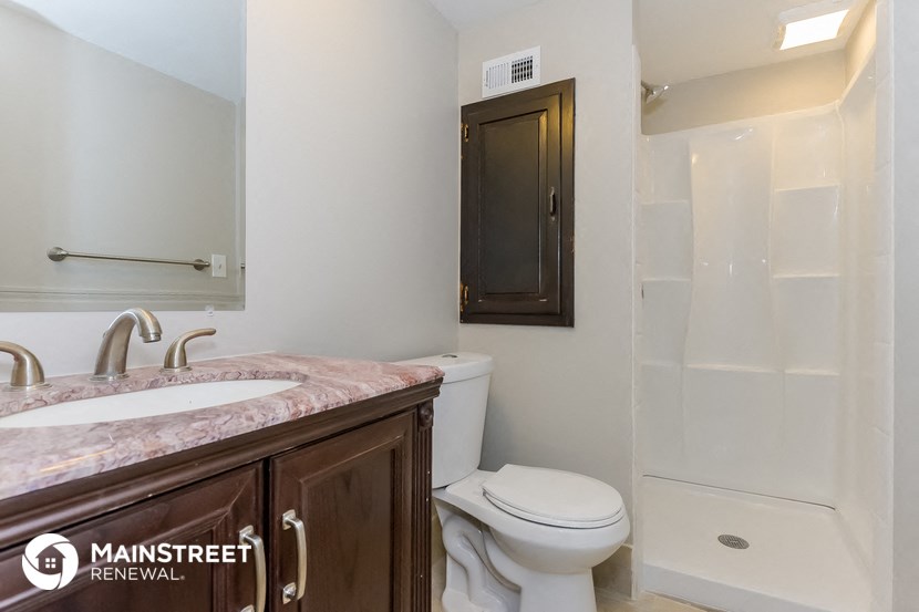 a bathroom with a toilet and a sink and a shower