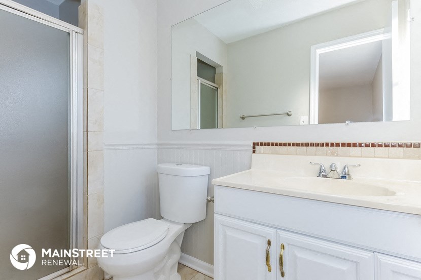 a bathroom with a toilet and a sink and a mirror