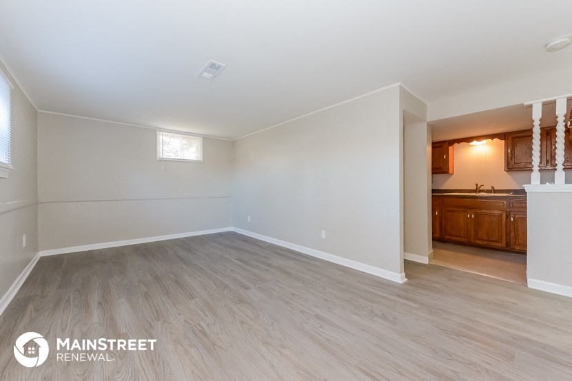 the living room and kitchen of an empty house