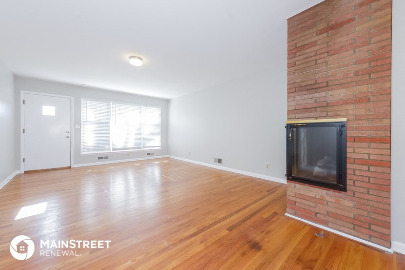 the living room with wood flooring and a fireplace