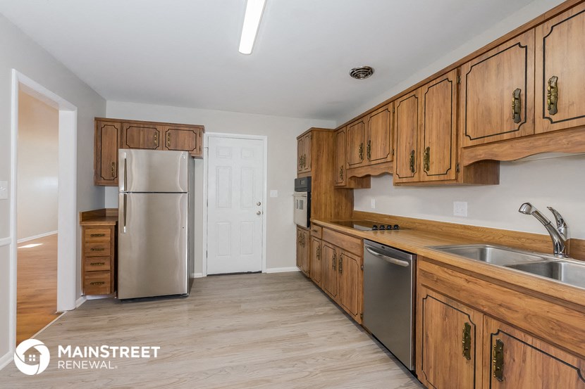 a kitchen with wooden cabinets and a stainless steel refrigerator