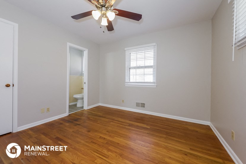the living room of a home with wood flooring and a ceiling fan