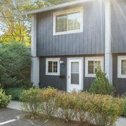 a house with a black and white facade and a sidewalk