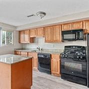 a kitchen with wooden cabinets and black appliances