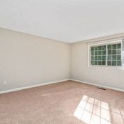 an empty room with a window and a pink carpet