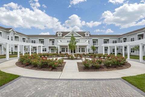 a large white building with a garden in front of it