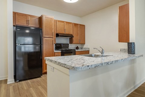 a kitchen with a granite counter top and a black refrigerator