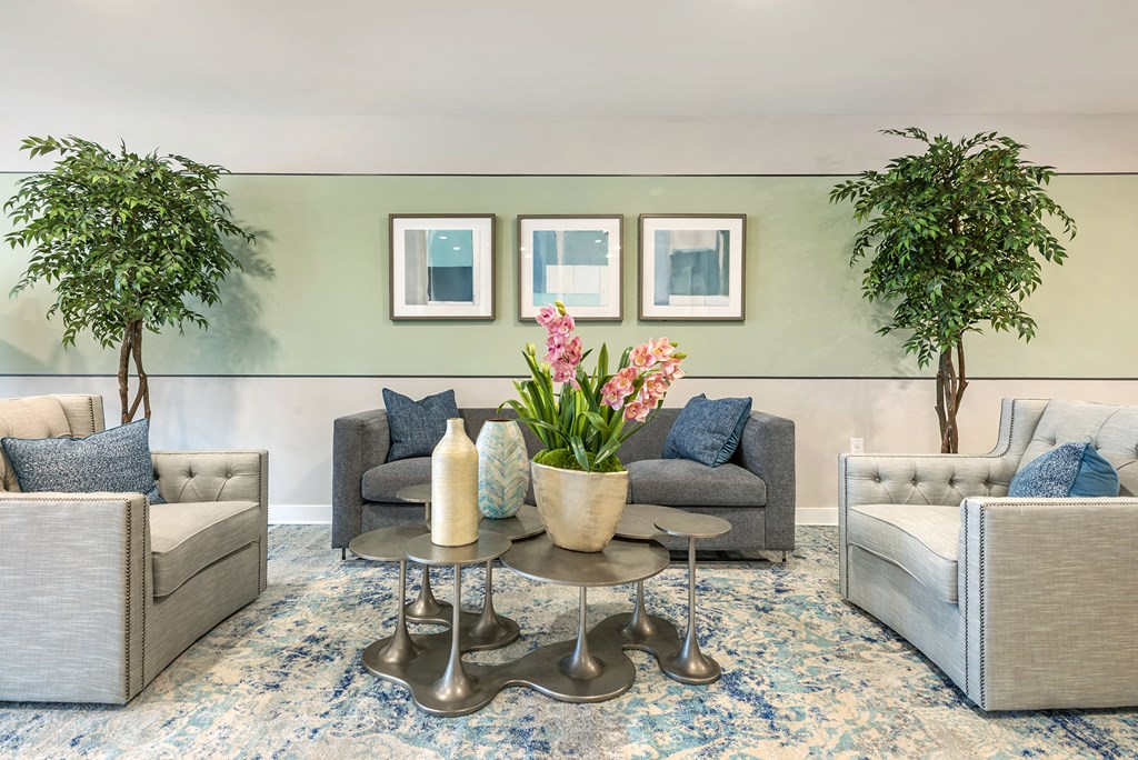 a living room with couches and chairs and plants