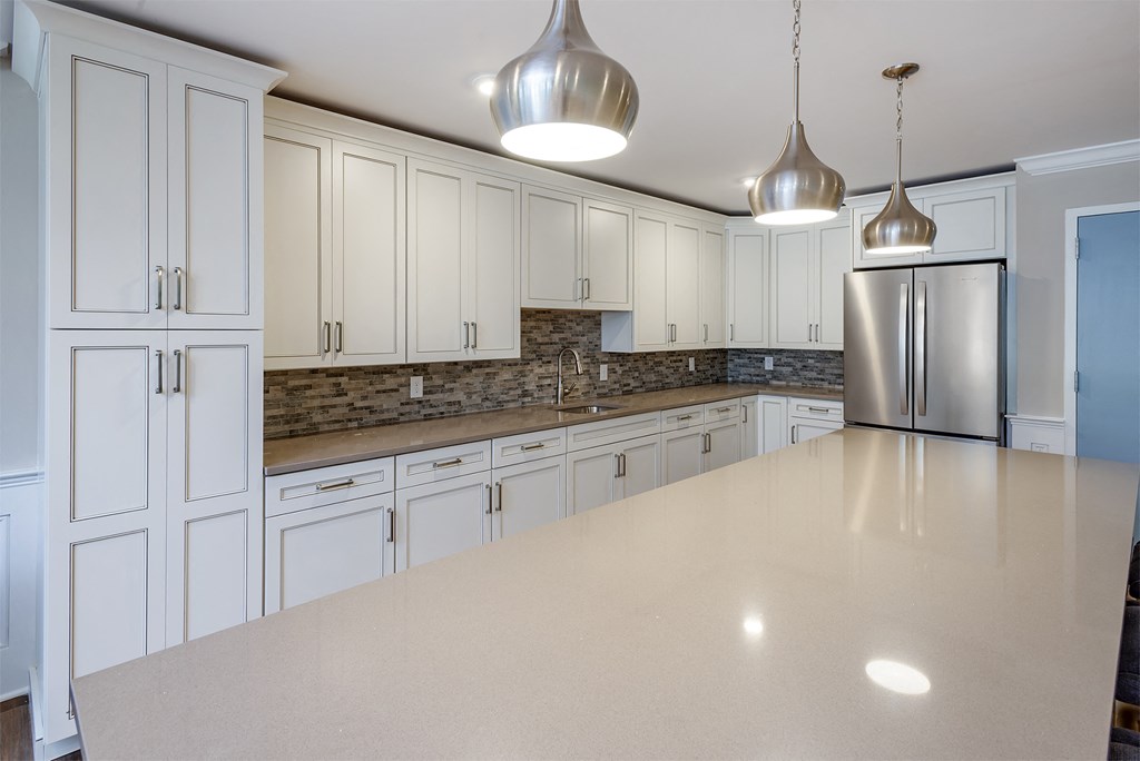 a large white kitchen with white cabinets and a white counter top