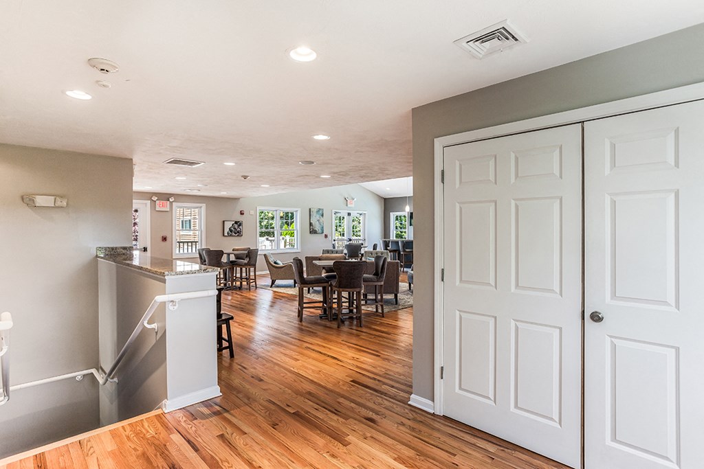 the living room and dining room of a home with white walls and wood floors