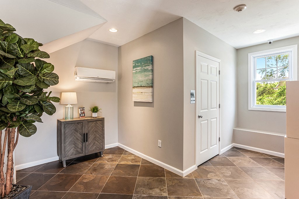 the entryway of a home with a white door and a plant