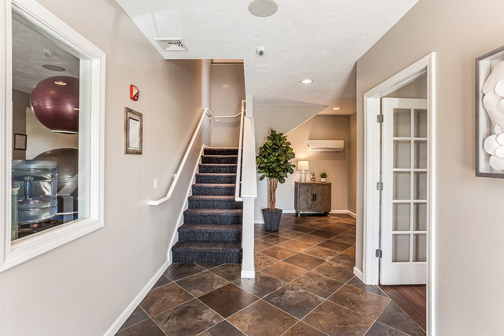 the entryway of a house with a staircase and a door
