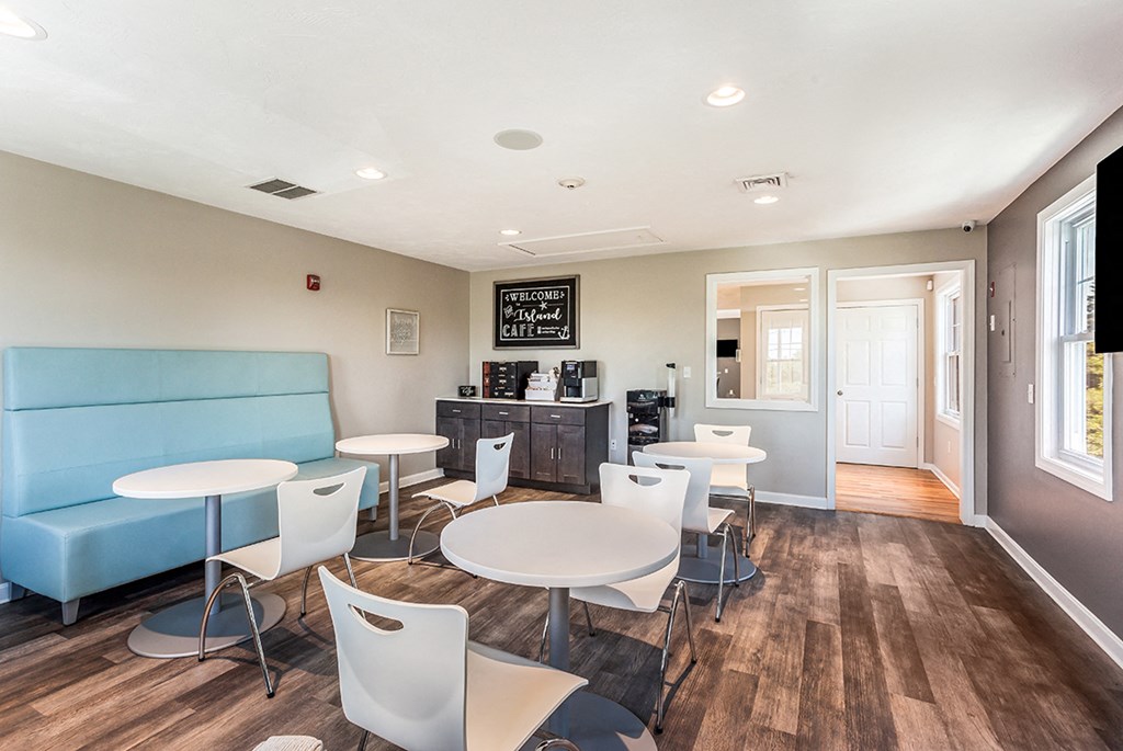 a community room with tables and chairs and a blue couch