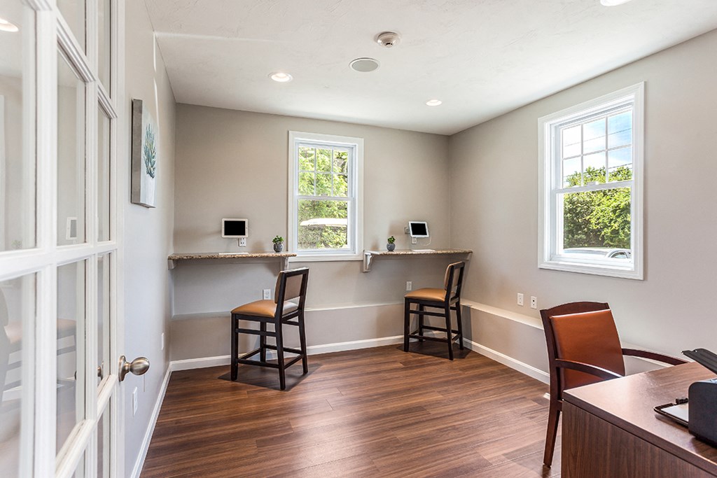 an empty room with two chairs and a bar with two windows