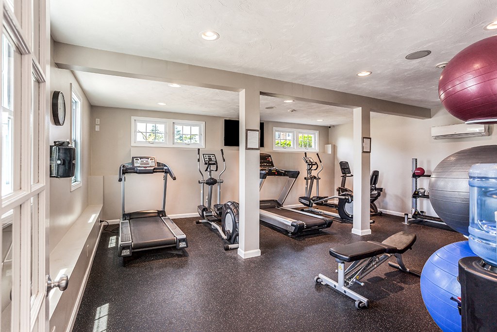 a home gym with exercise equipment and windows