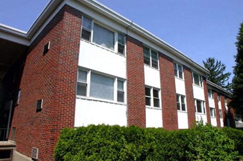 a red brick building with bushes in front of it
