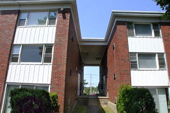 the front of a brick house with a covered walkway