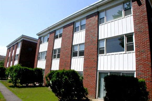 a large brick building with a sidewalk in front of it
