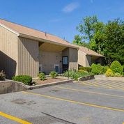a church building with a parking lot and trees