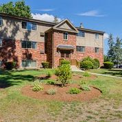 a large brick house with a garden in front of it