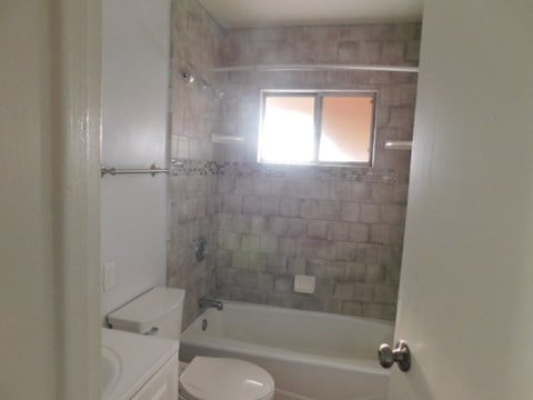 a bathroom with a tub and a toilet and a window