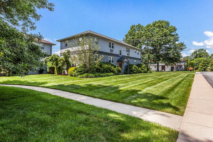 a large house with a lawn and trees in front of it