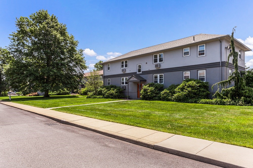 a white house with a sidewalk and lawn in front of it