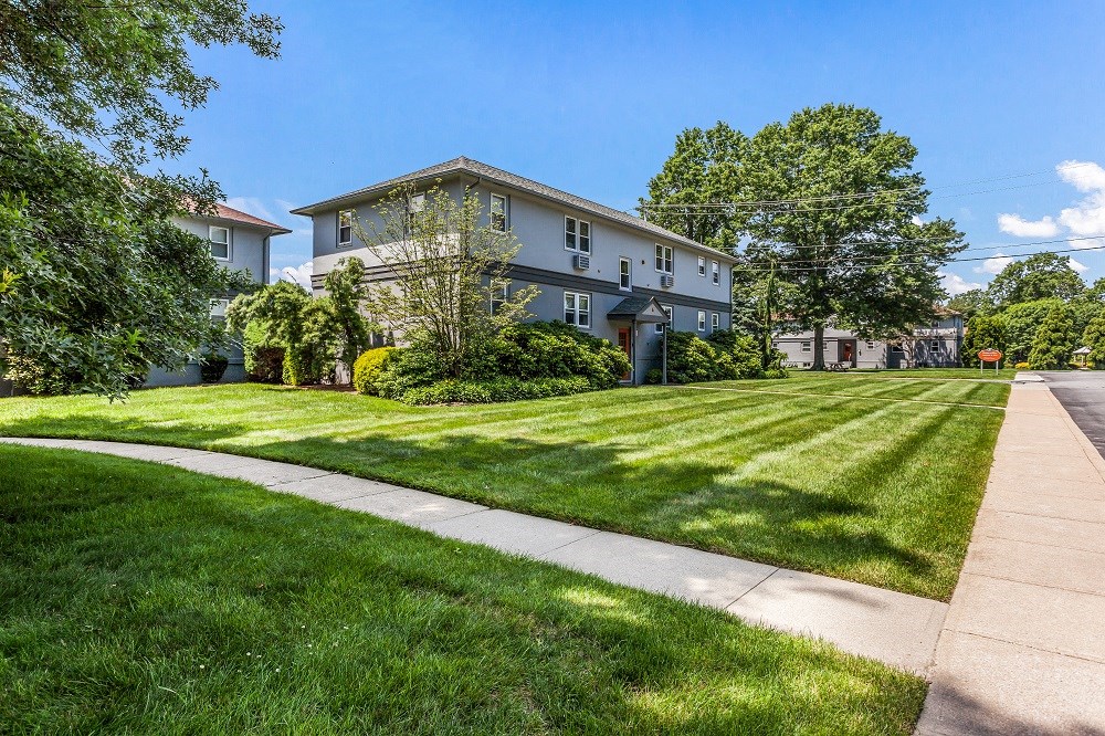 a house with a lawn and a sidewalk in front of it