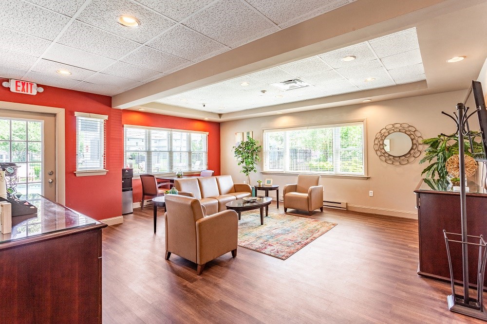 a living room with couches and chairs and a reception desk