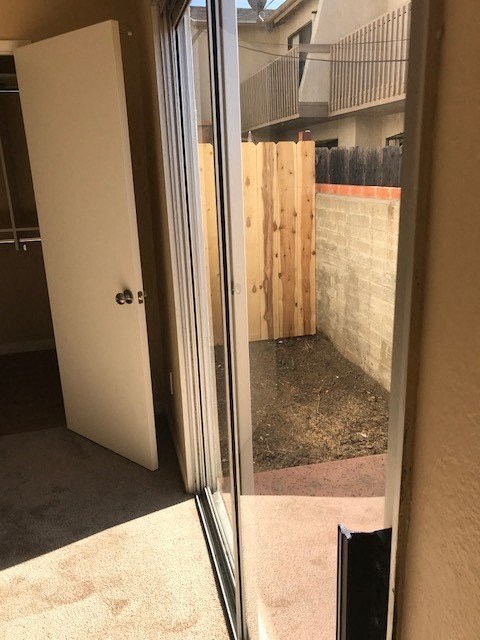 A white door is open to a backyard.