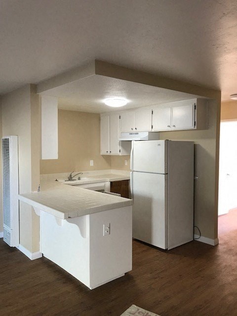 A kitchen with white appliances and cabinets.