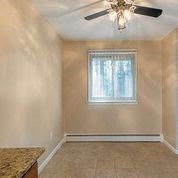 an empty room with a ceiling fan and a window