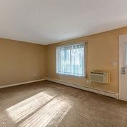 an empty living room with a window and a radiator