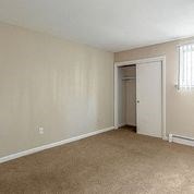 an empty bedroom with a door to a closet