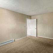 an empty living room with a door to a bedroom