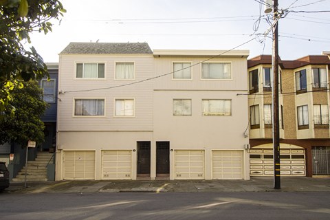 A two-story building with a garage door is in the foreground.