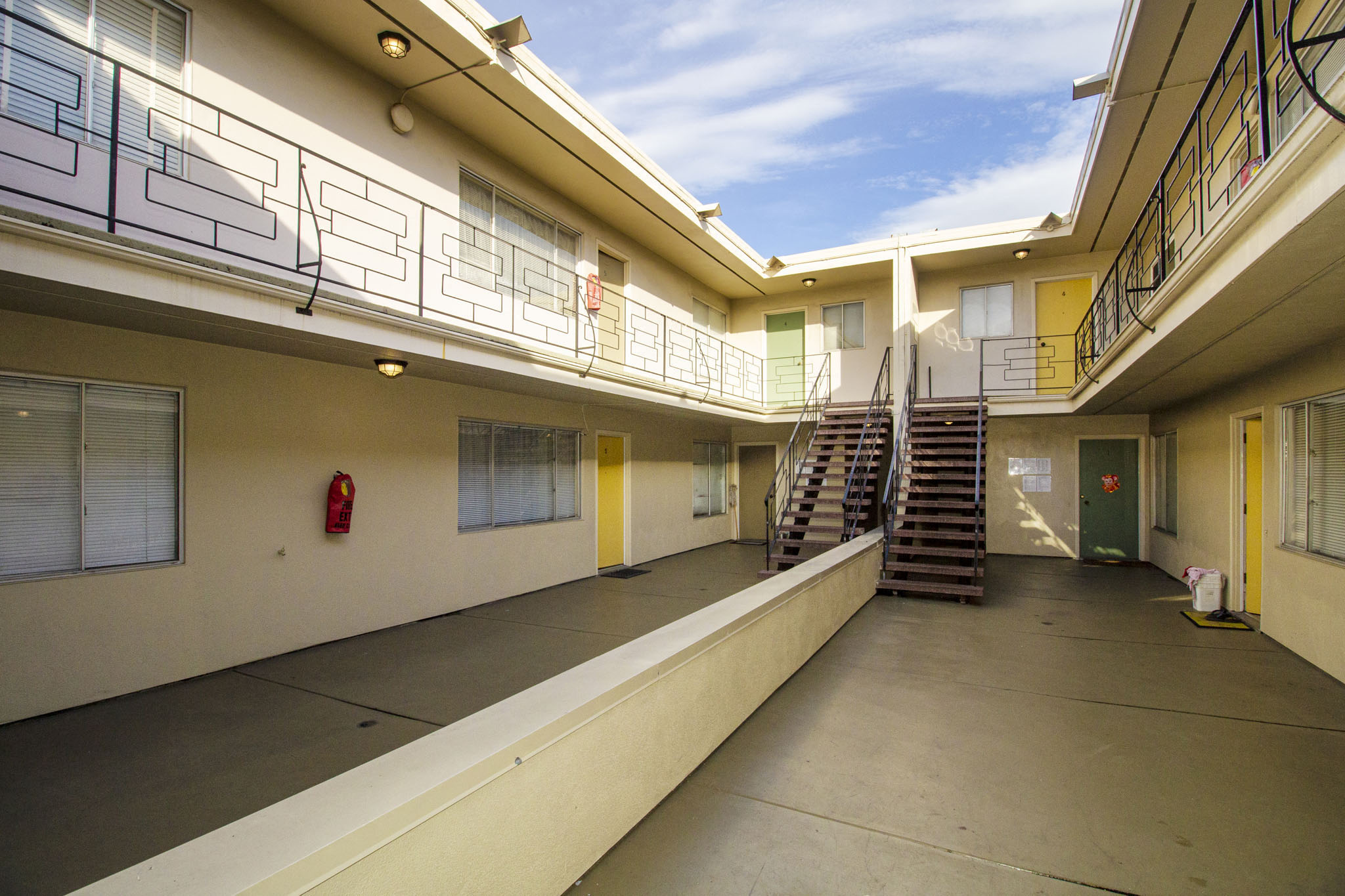 A long hallway with a staircase and a fire extinguisher.